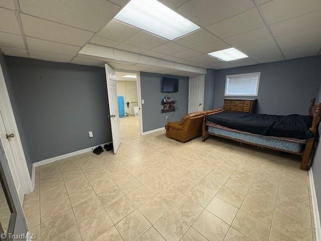 bedroom with baseboards and a paneled ceiling