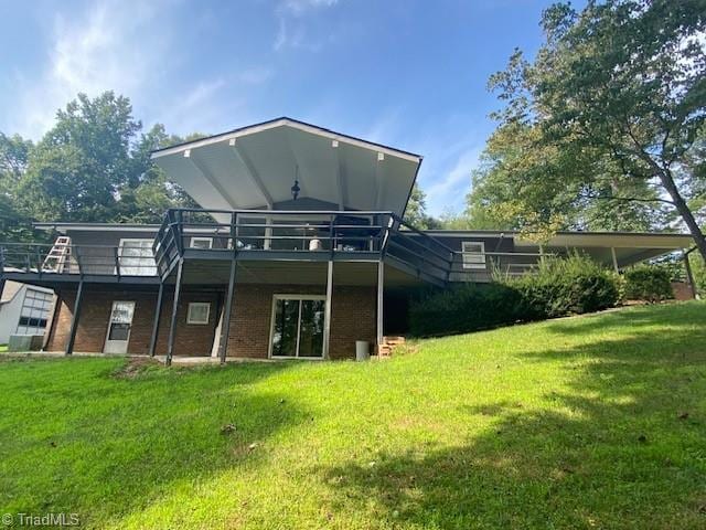 back of house featuring a wooden deck and a lawn