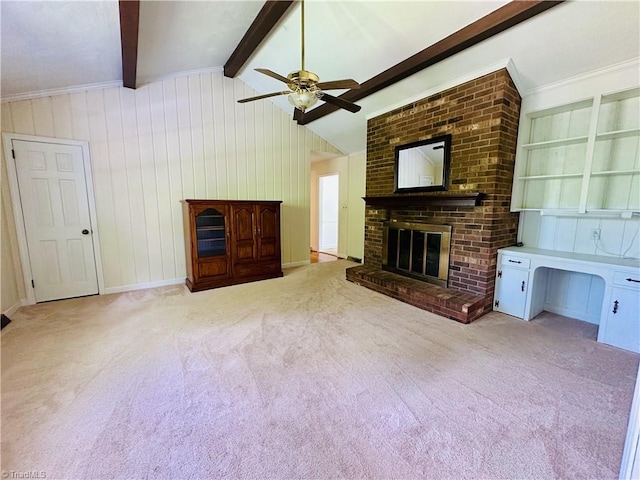 unfurnished living room featuring carpet flooring, ceiling fan, wood walls, lofted ceiling with beams, and a fireplace