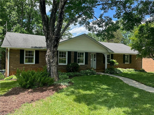 single story home featuring brick siding and a front yard