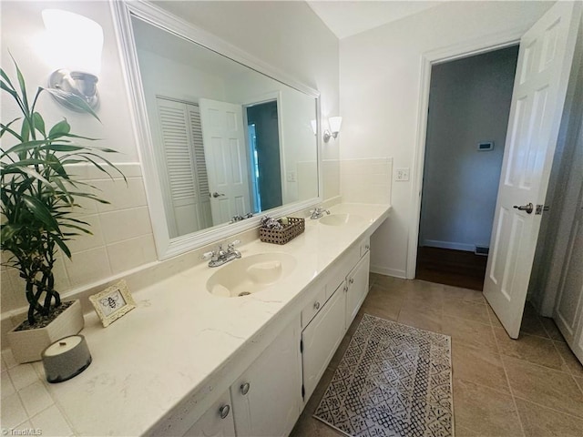 bathroom with double vanity, tile patterned flooring, and a sink