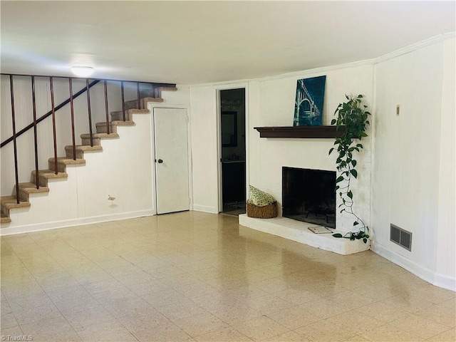 unfurnished living room featuring a brick fireplace, visible vents, baseboards, and stairway