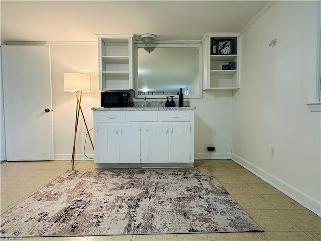 kitchen with open shelves, baseboards, white cabinets, and black microwave