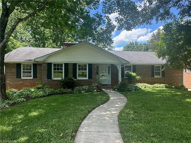 ranch-style house featuring brick siding and a front lawn