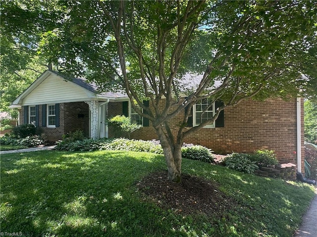 single story home with a front lawn and brick siding