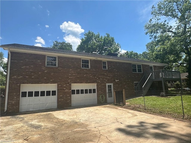 view of front of house with stairs, an attached garage, brick siding, and driveway