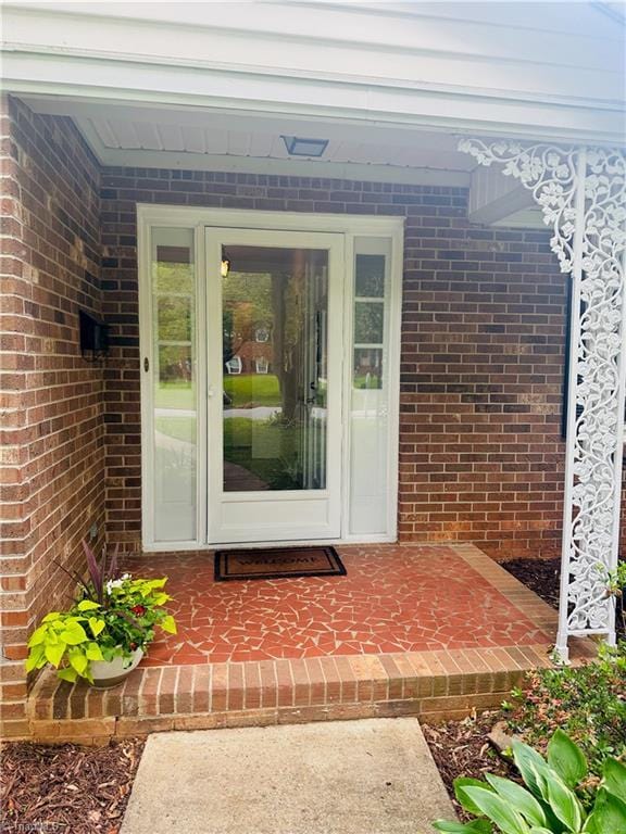 entrance to property featuring brick siding