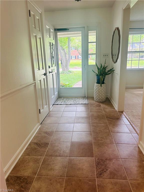 doorway to outside featuring dark tile patterned floors and baseboards