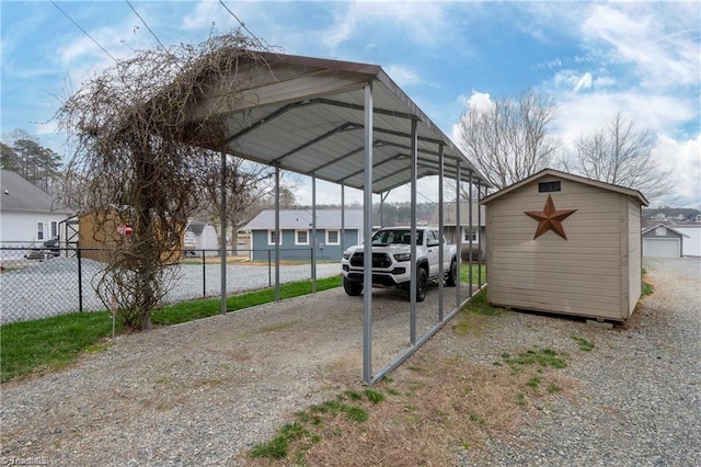 view of vehicle parking featuring a residential view, gravel driveway, fence, a shed, and a detached carport