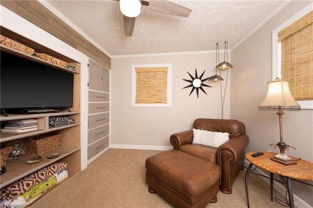 living area featuring a ceiling fan, carpet, crown molding, and baseboards