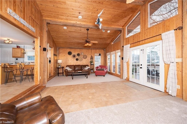 carpeted living area with plenty of natural light, wood ceiling, wooden walls, and high vaulted ceiling