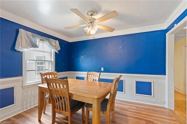 dining space featuring hardwood / wood-style flooring, ceiling fan, and crown molding