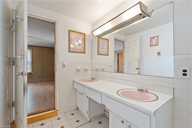 bathroom featuring tile patterned flooring, vanity, and tile walls