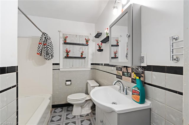 full bathroom with vanity, toilet, tile walls, and bathtub / shower combination