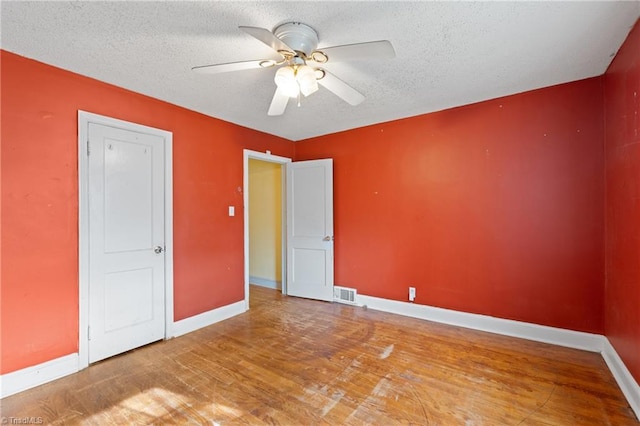 unfurnished bedroom with ceiling fan, a textured ceiling, and hardwood / wood-style flooring