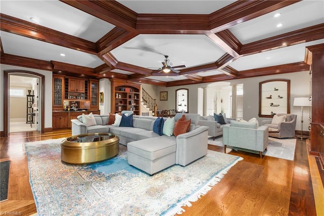 living room with coffered ceiling, beamed ceiling, and ornate columns