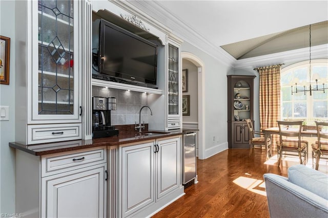 bar with vaulted ceiling, dark hardwood / wood-style floors, pendant lighting, sink, and wine cooler