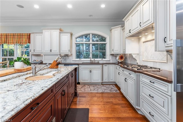 kitchen with plenty of natural light, sink, stainless steel gas cooktop, and white cabinets