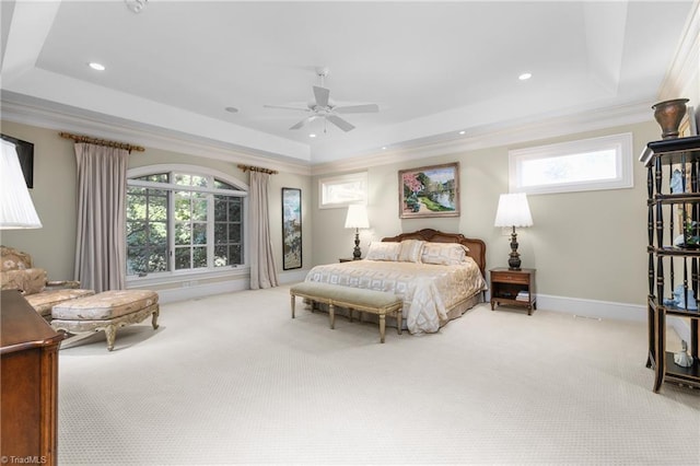 carpeted bedroom featuring crown molding, a tray ceiling, and multiple windows