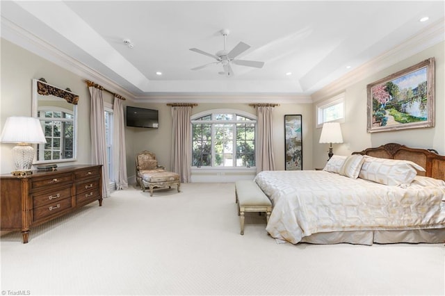 bedroom with multiple windows, ornamental molding, light colored carpet, and a raised ceiling