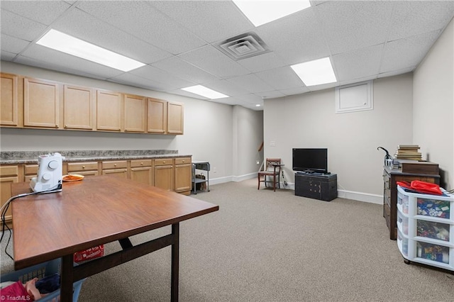 carpeted home office featuring a paneled ceiling