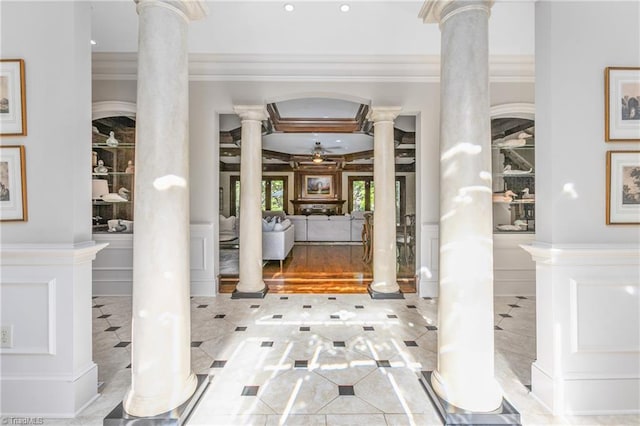 foyer entrance with ornate columns, ornamental molding, and ceiling fan