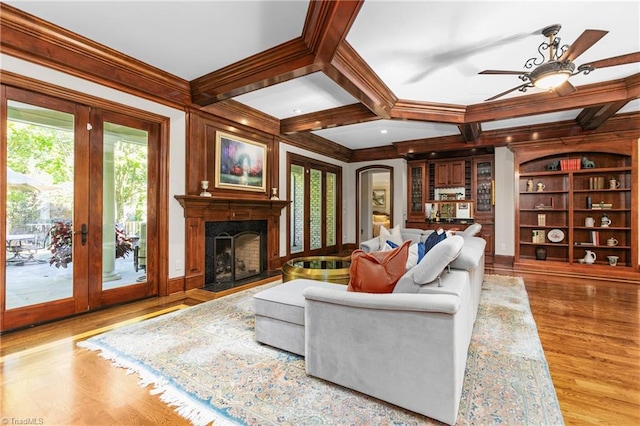 living room featuring beamed ceiling, coffered ceiling, and light hardwood / wood-style flooring