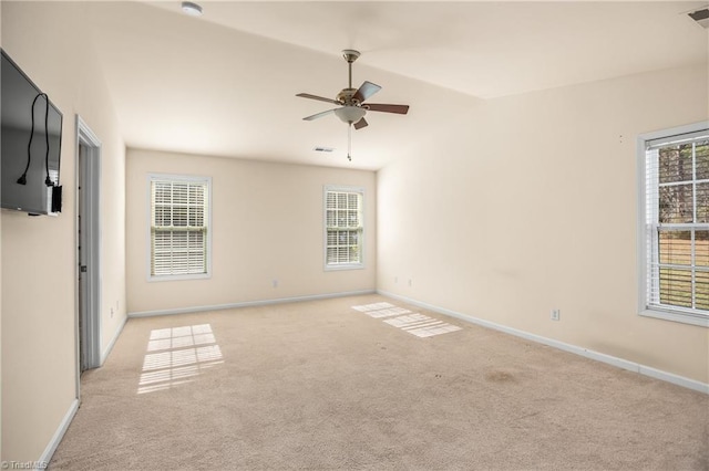 unfurnished room featuring ceiling fan, light colored carpet, plenty of natural light, and vaulted ceiling