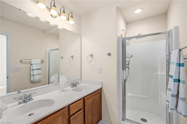 bathroom featuring a shower with door and vanity