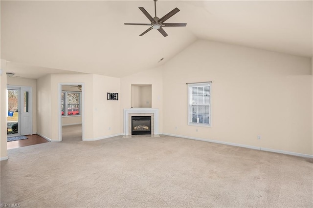 unfurnished living room with high vaulted ceiling, light colored carpet, and ceiling fan