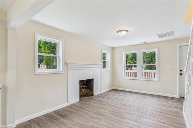3885 Leo St, Winston-Salem, NC 27105 - unfurnished living room with wood finished floors and a brick fireplace