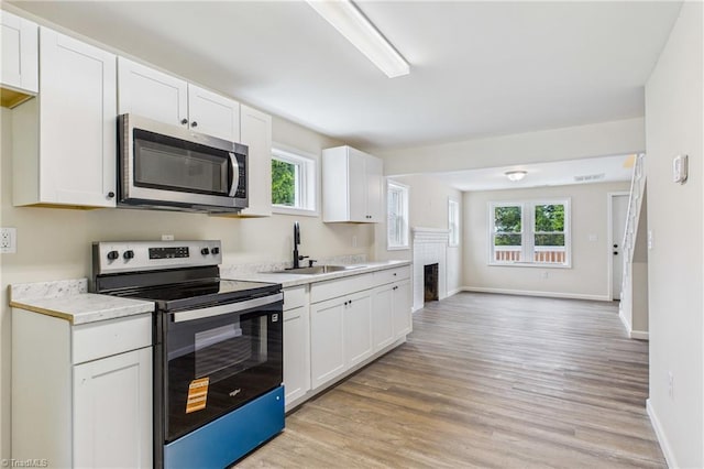 3885 Leo St, Winston-Salem, NC 27105 - kitchen featuring stainless steel appliances, light wood-type flooring, light countertops, and healthy amount of natural light