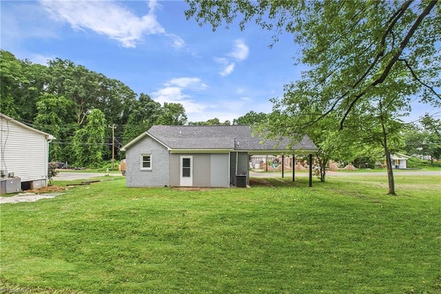 3885 Leo St, Winston-Salem, NC 27105 - rear view of house with a lawn, an attached carport, and roof with shingles
