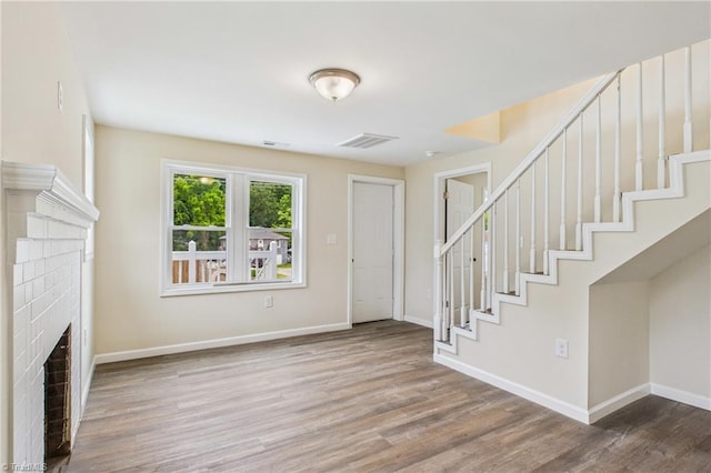 3885 Leo St, Winston-Salem, NC 27105 - entrance foyer with a brick fireplace, wood finished floors, and stairs