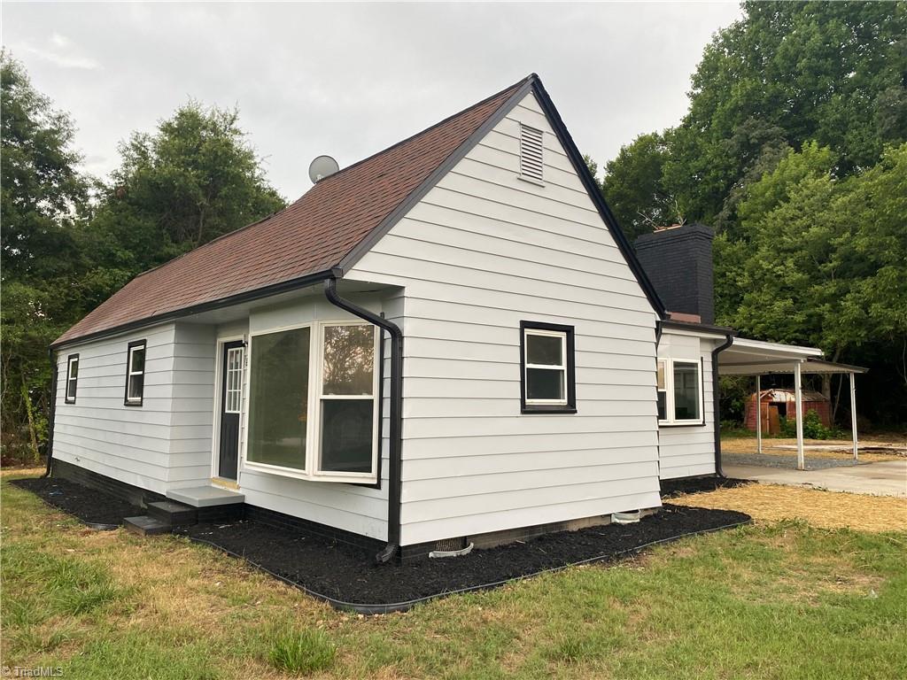 view of side of property with a carport and a yard