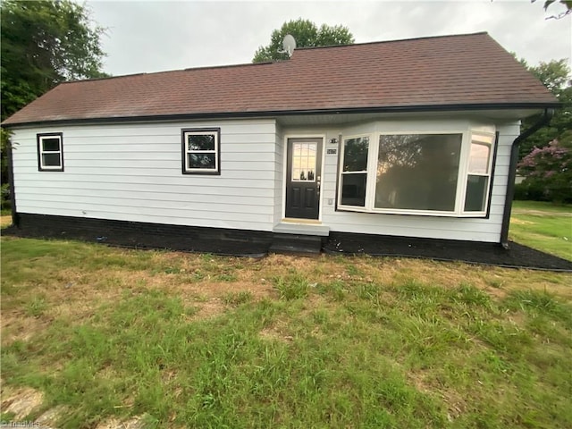 back of property featuring a lawn