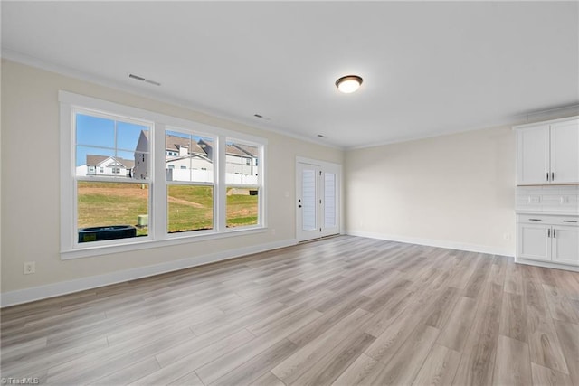 unfurnished living room featuring light wood-style flooring, baseboards, and ornamental molding