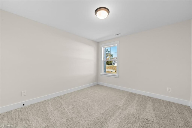 empty room featuring light colored carpet and baseboards