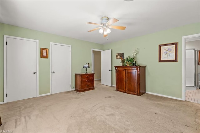 unfurnished bedroom featuring light carpet, ensuite bath, and ceiling fan