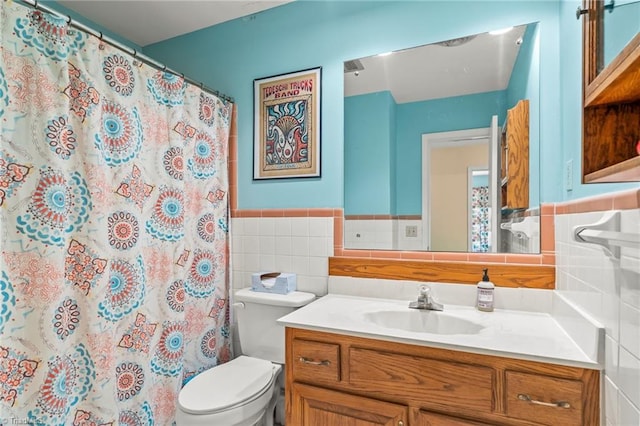 bathroom with a shower with curtain, vanity, tile walls, and toilet