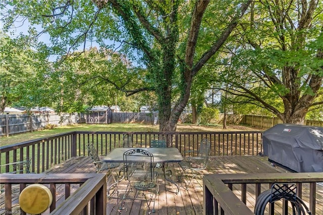 wooden terrace featuring area for grilling and a storage unit