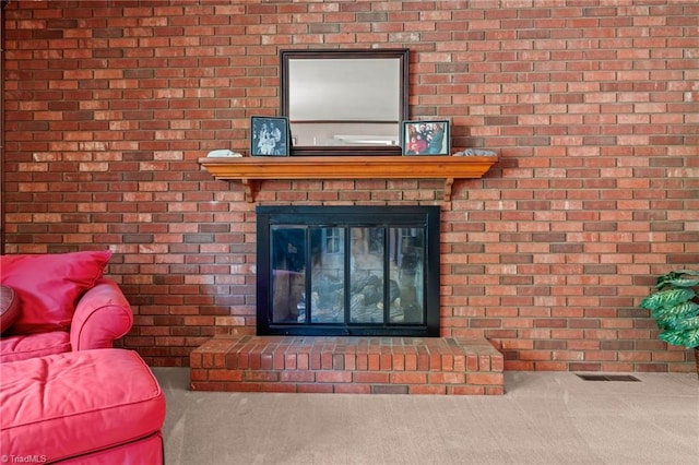 room details featuring a brick fireplace and carpet