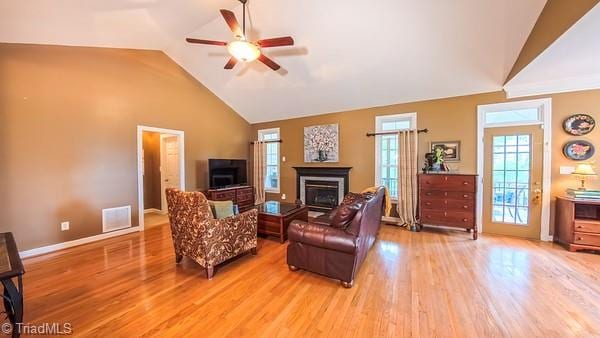 5110 Hartridge Way, Greensboro, NC 27407 - living room with a ceiling fan, light wood finished floors, a glass covered fireplace, baseboards, and high vaulted ceiling