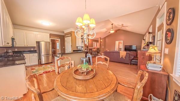 5110 Hartridge Way, Greensboro, NC 27407 - dining space with a chandelier, light wood-type flooring, a ceiling fan, and lofted ceiling