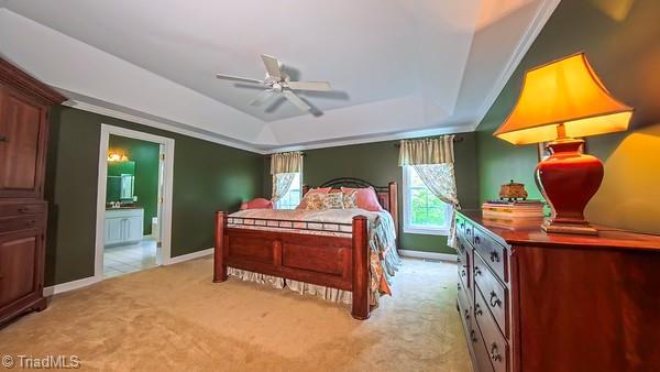 5110 Hartridge Way, Greensboro, NC 27407 - bedroom featuring a raised ceiling, light colored carpet, baseboards, ensuite bathroom, and ornamental molding