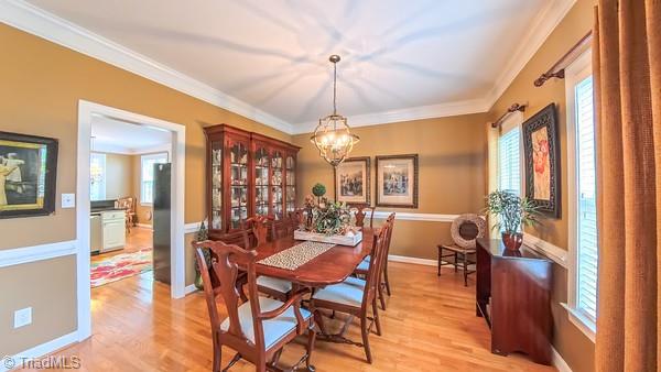5110 Hartridge Way, Greensboro, NC 27407 - dining area with a chandelier, ornamental molding, and light wood finished floors