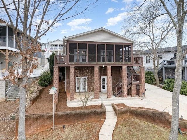 back of property with a patio area and a sunroom