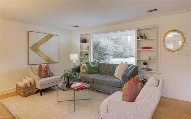 living area with visible vents, baseboards, and wood finished floors