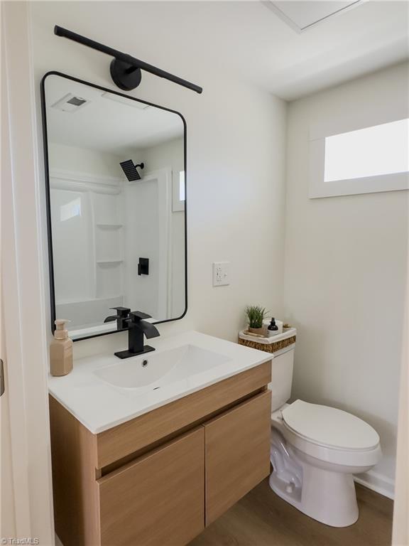 bathroom with vanity, hardwood / wood-style floors, and toilet