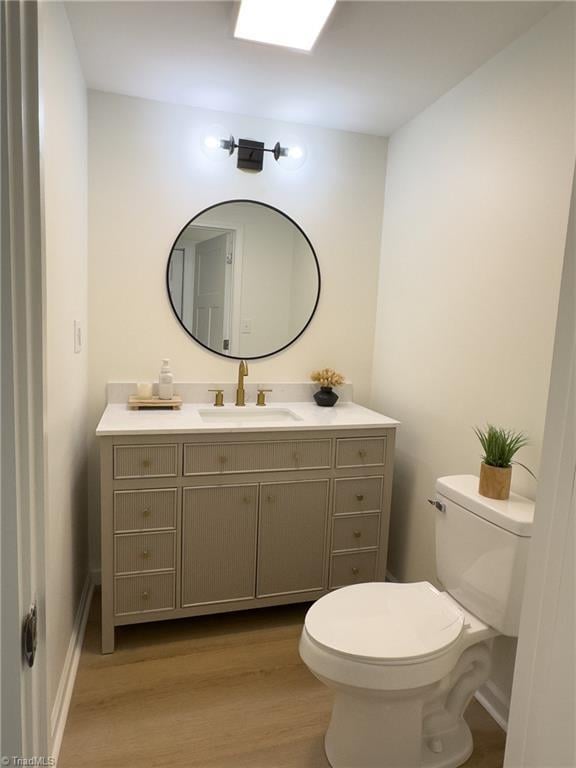 bathroom featuring hardwood / wood-style flooring, vanity, and toilet